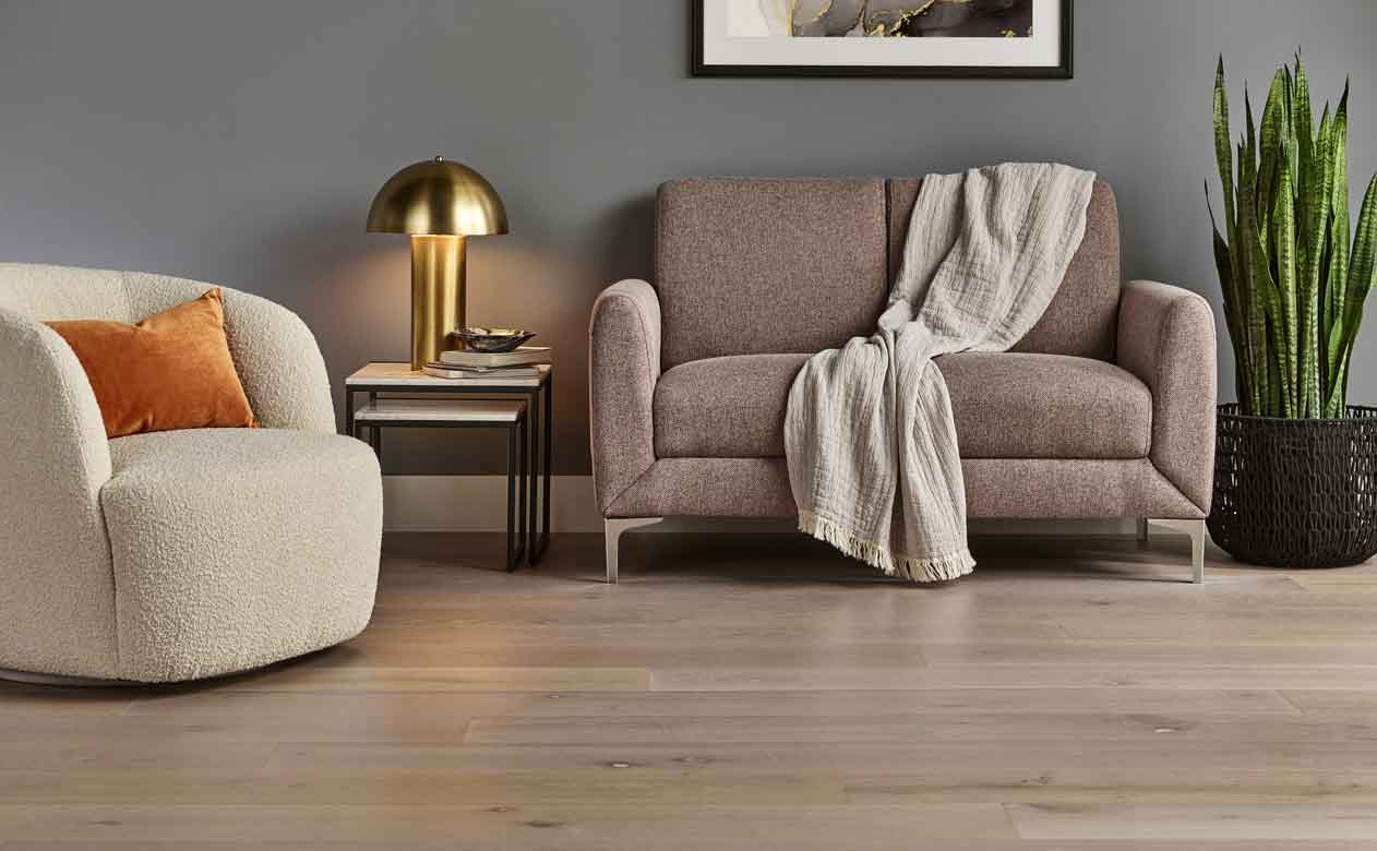 Hardwood flooring in a living room with a beige accent chair